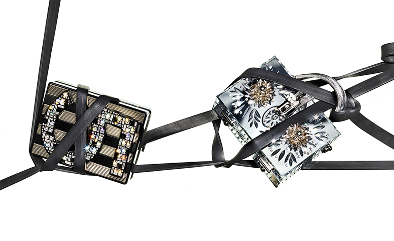 A la izquierda, caja en piel bicolor con detalles de strass, de Chanel; a la derecha, bolsito de mano en piel plateada con aplicaciones metalizadas, de Dolce&Gabbana. © Lucio Convertini