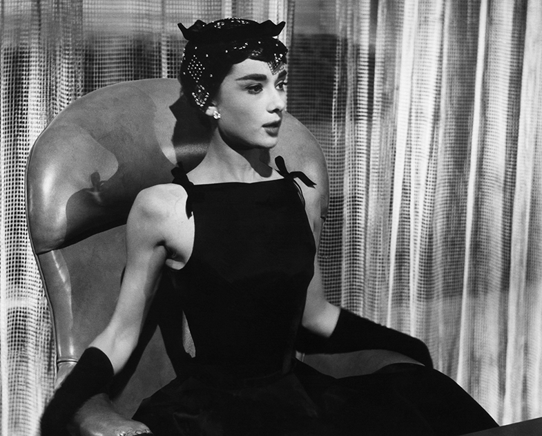 Audrey con el vestido negro de escote alto que cubría sus clavículas y que desde ese momento pasó a conocerse como 'escote Sabrina'. © Cordon Press