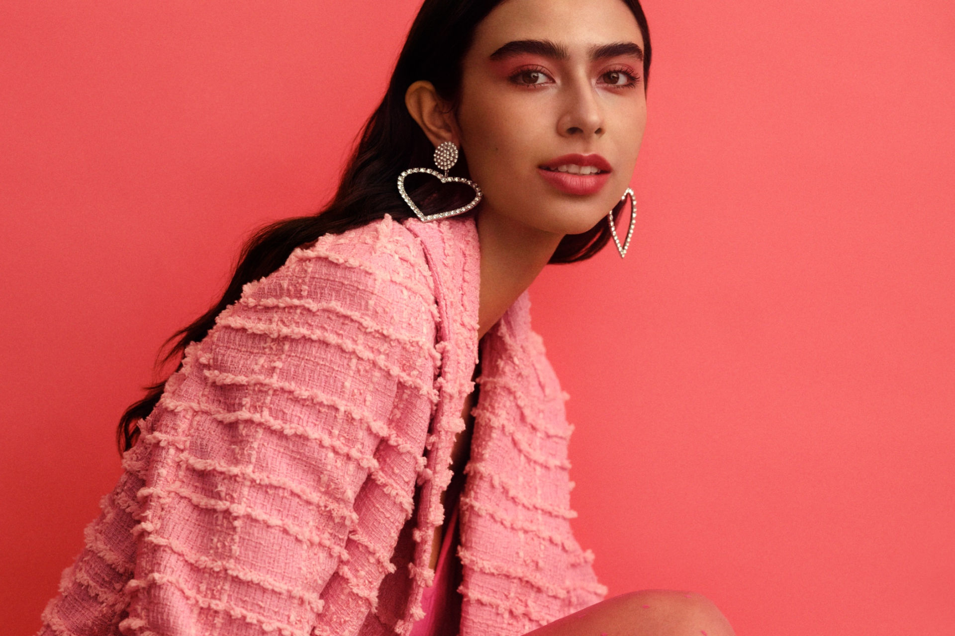 Beauty Valentine’s gifts: H&M Crushing on Beauty campaign image featuring a model with pink jacket and makeup on red background
