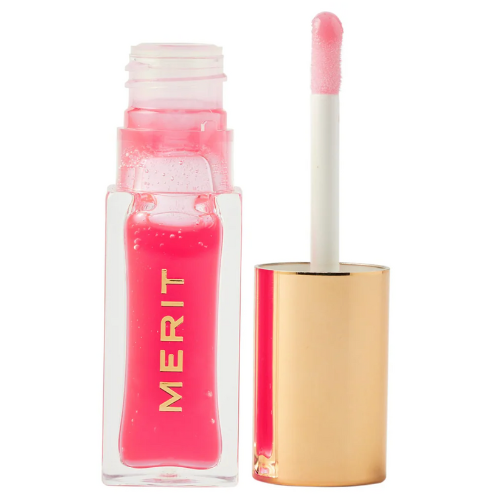 A packshot of the Merit Beauty Shade Slick Gelée Sheer Tinted Lip Oil. A bright pink shade of the product is placed against a white background.