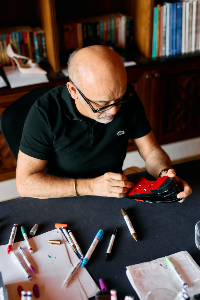 The creative director signs shoes for VIP guests in the new Abu Dhabi boutique