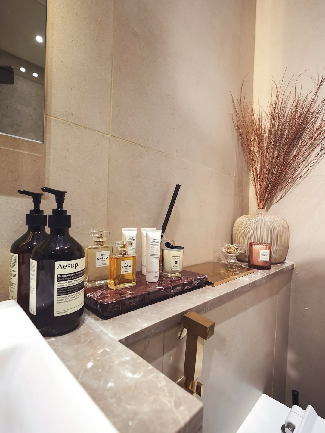 Bathroom shelf styled with high-end perfumes and products 