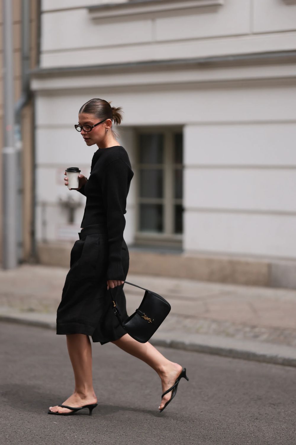 Conjunto monocromático negro con bermudas y sandalias de tacón.