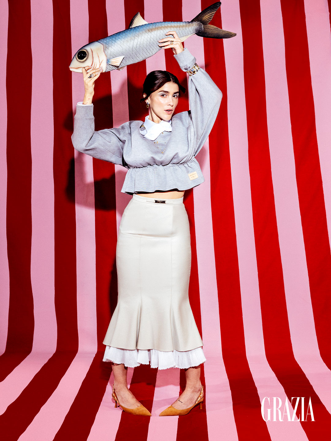 Cassandra Sanchez Navarro sosteniendo una sardina gigante para fotografías de Grazia México
