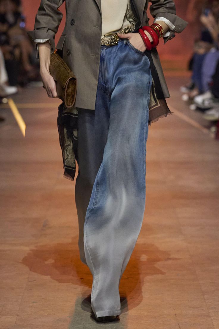 Pantalón de mezclilla de tiro medio con efecto degradado (wash), combinado con un blazer estructurado gris, cinturón y accesorios en tonos tierra para otoño