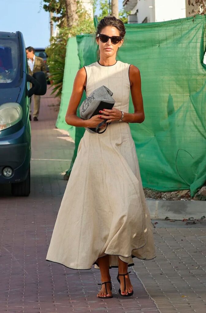 Vestido midi beige sin mangas con falda de vuelo y bolso de mano