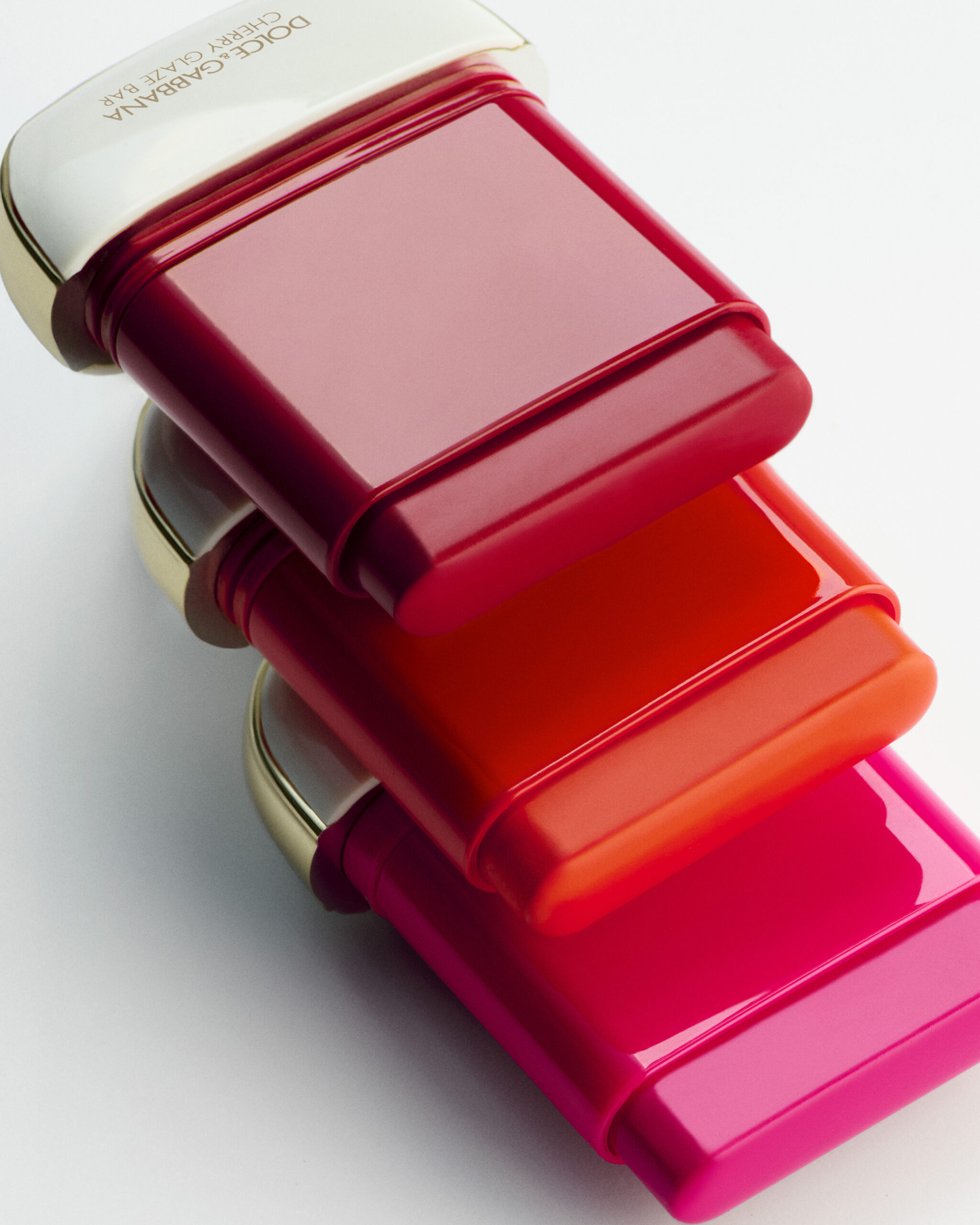 Primer plano de tres barras de Cherry Glaze apiladas, mostrando diferentes tonalidades vibrantes de rojo, naranja y fucsia.