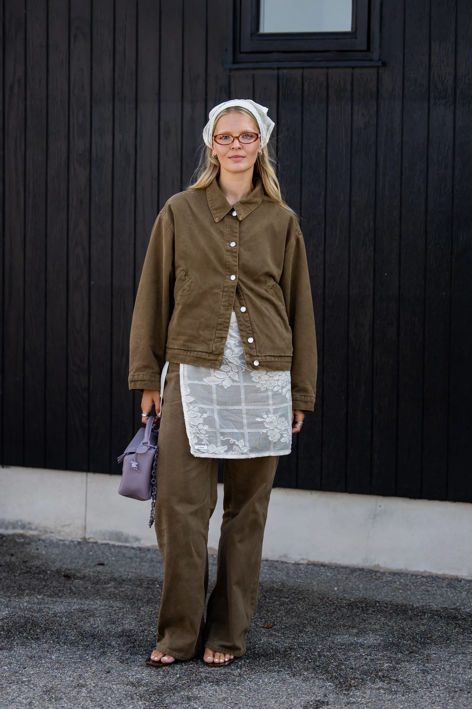 Mujer con chaqueta caqui, pañuelo blanco y anteojos.