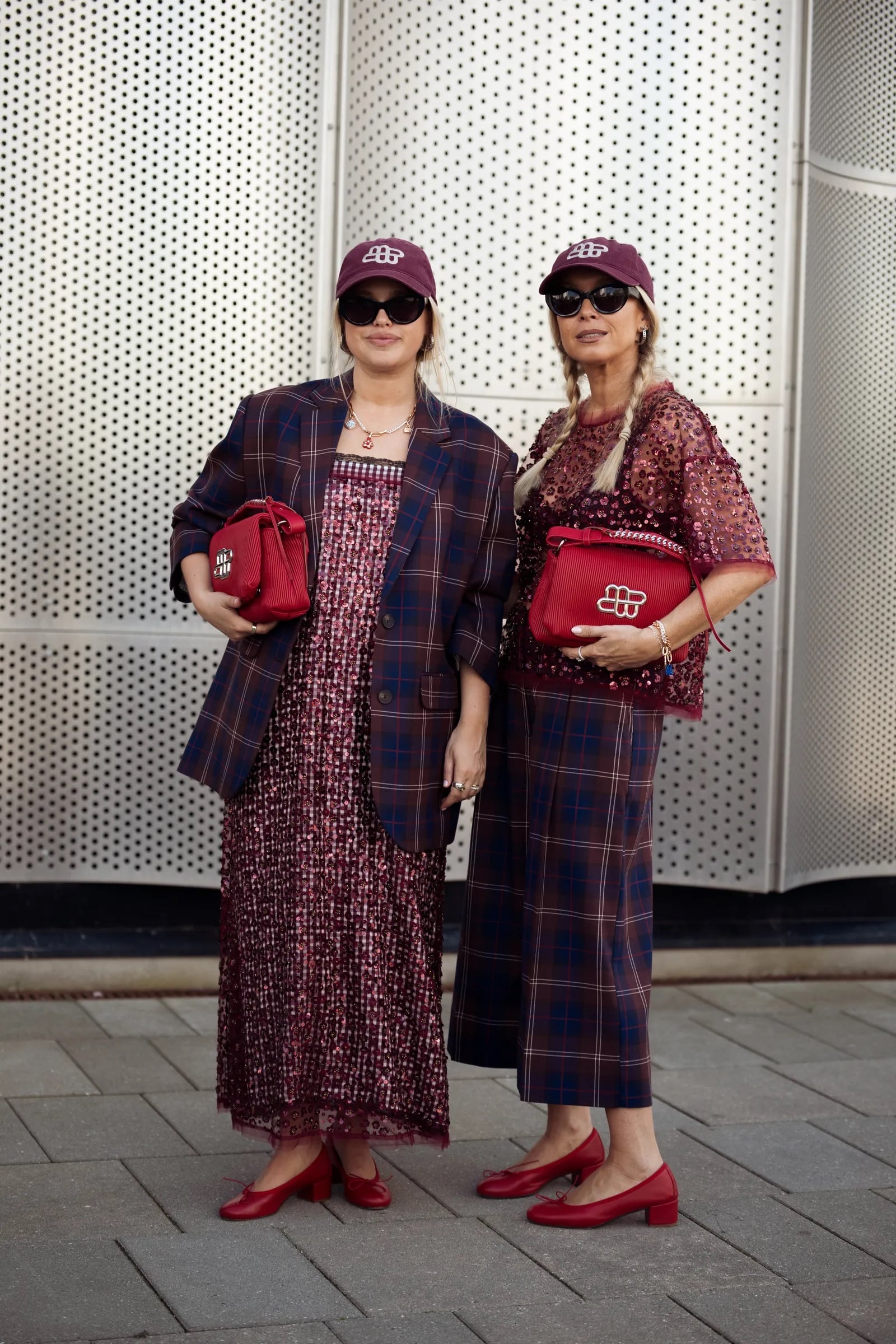 Dos mujeres con abrigos a cuadros y gorras borgoña