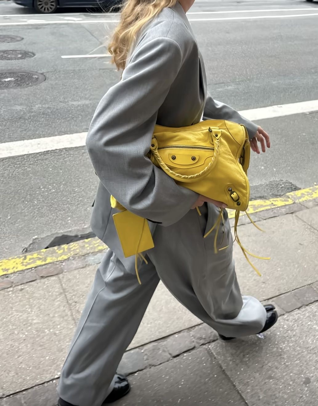 Mujer caminando con bolso amarillo de Balenciaga