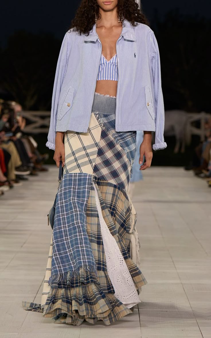 Modelo con chaqueta de rayas azul y blanca, crop top a juego y falda larga de paneles con estampado de cuadros patchwork.