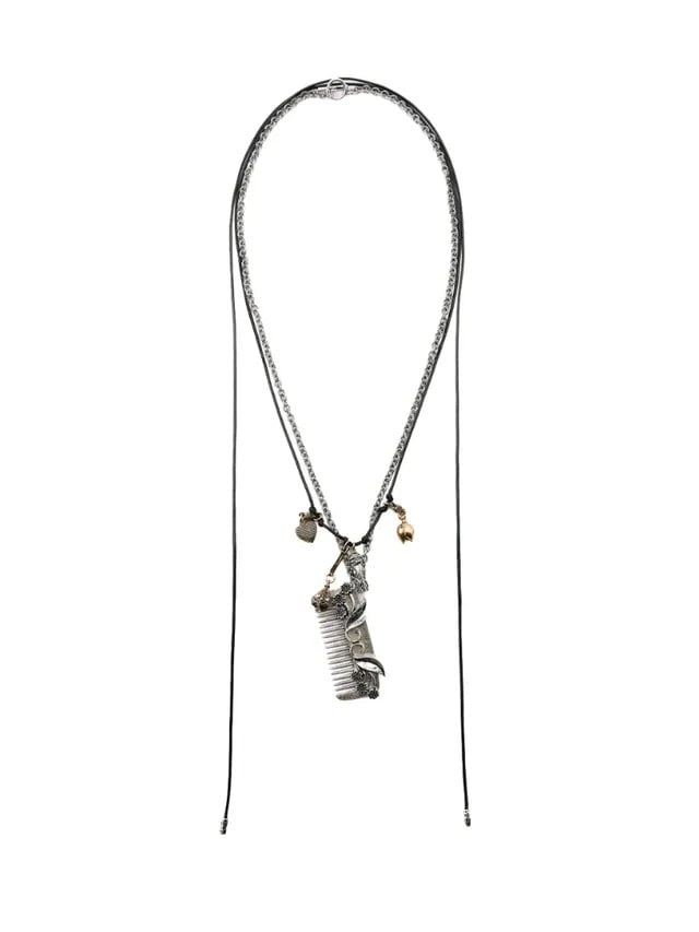 Collar largo de doble tira con un dije colgante en forma de peine plateado envejecido decorado con detalles florales y abalorios pequeños.