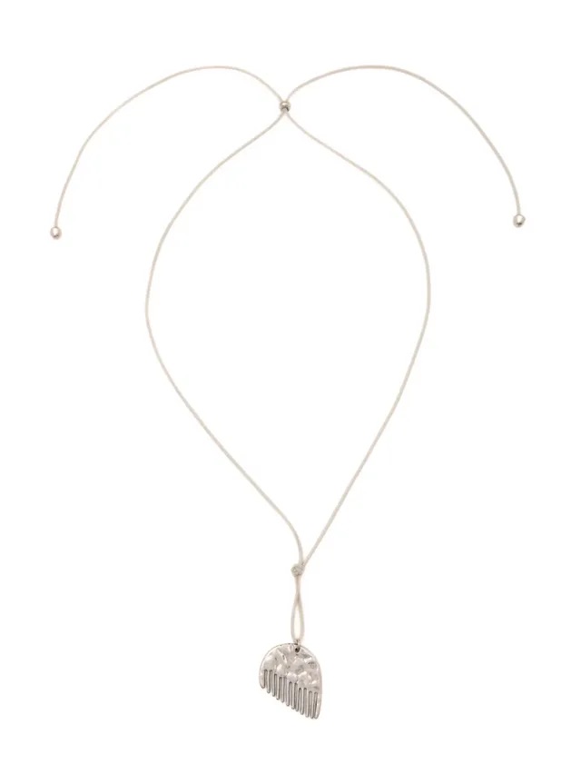 Collar minimalista con cordón claro ajustable y un dije plateado de peine con textura martillada en forma semicircular.