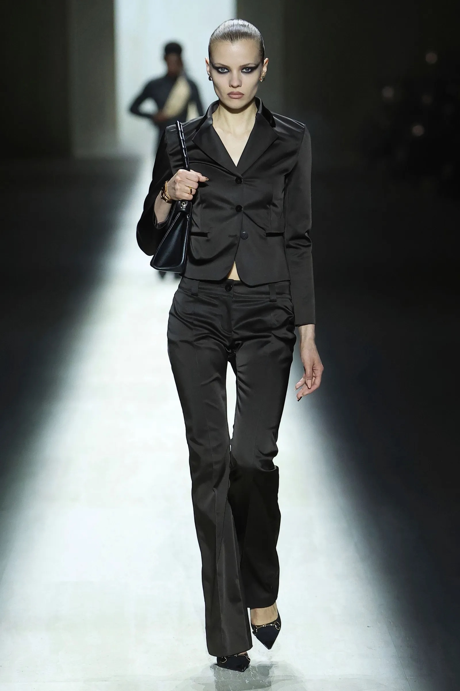 Modelo con chaqueta sastre y pantalón negro recto de estilo minimalista noventero.
