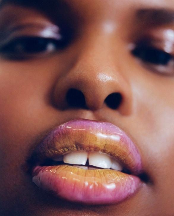 Modelo con labios delineados y maquillados en un tono azul marino profundo de acabado mate, contrastando con una piel luminosa y sombras sutiles.