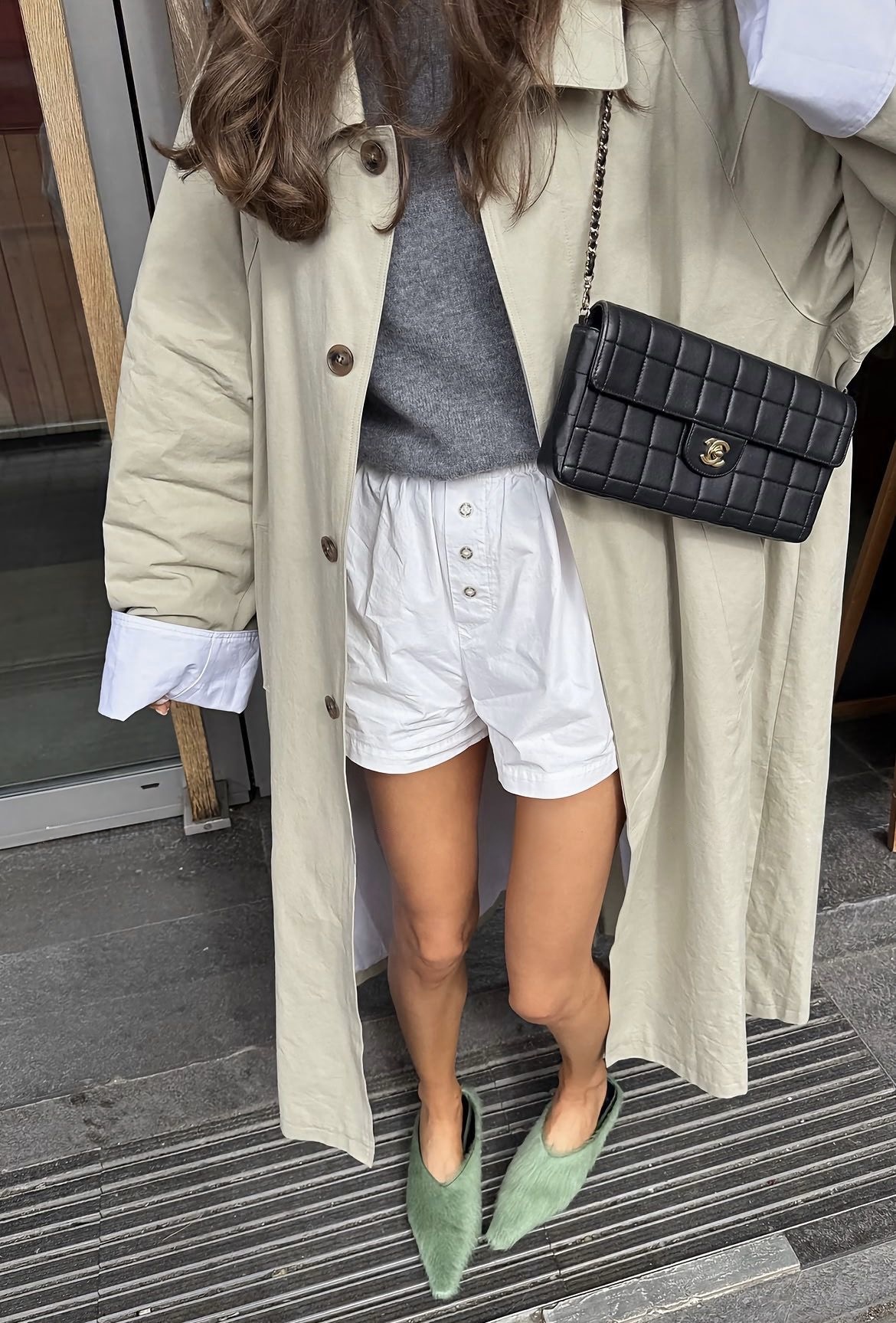 Gabardina con shorts blancos y suéter gris