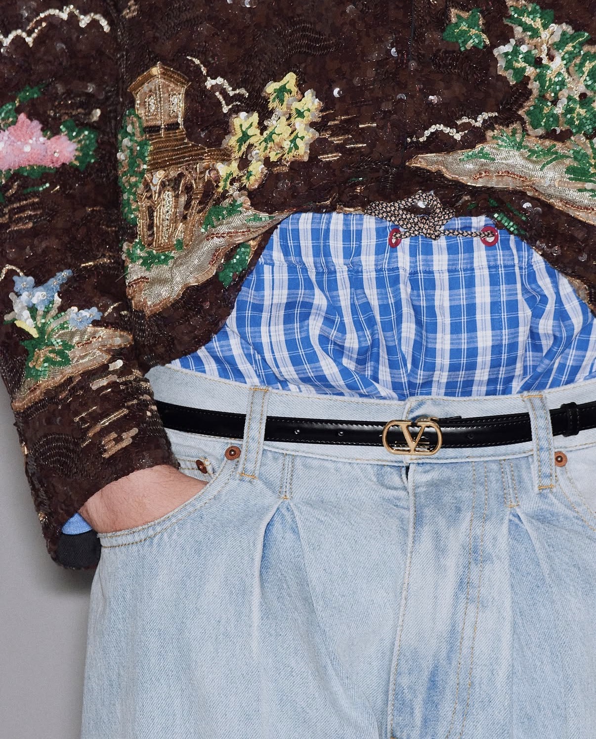 Jeans con cinturón de Valentino y camisa azul de cuadros