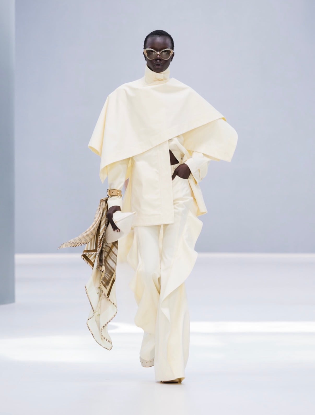 Modelo con capa y pantalón crema y lentes redondos Zimmermann