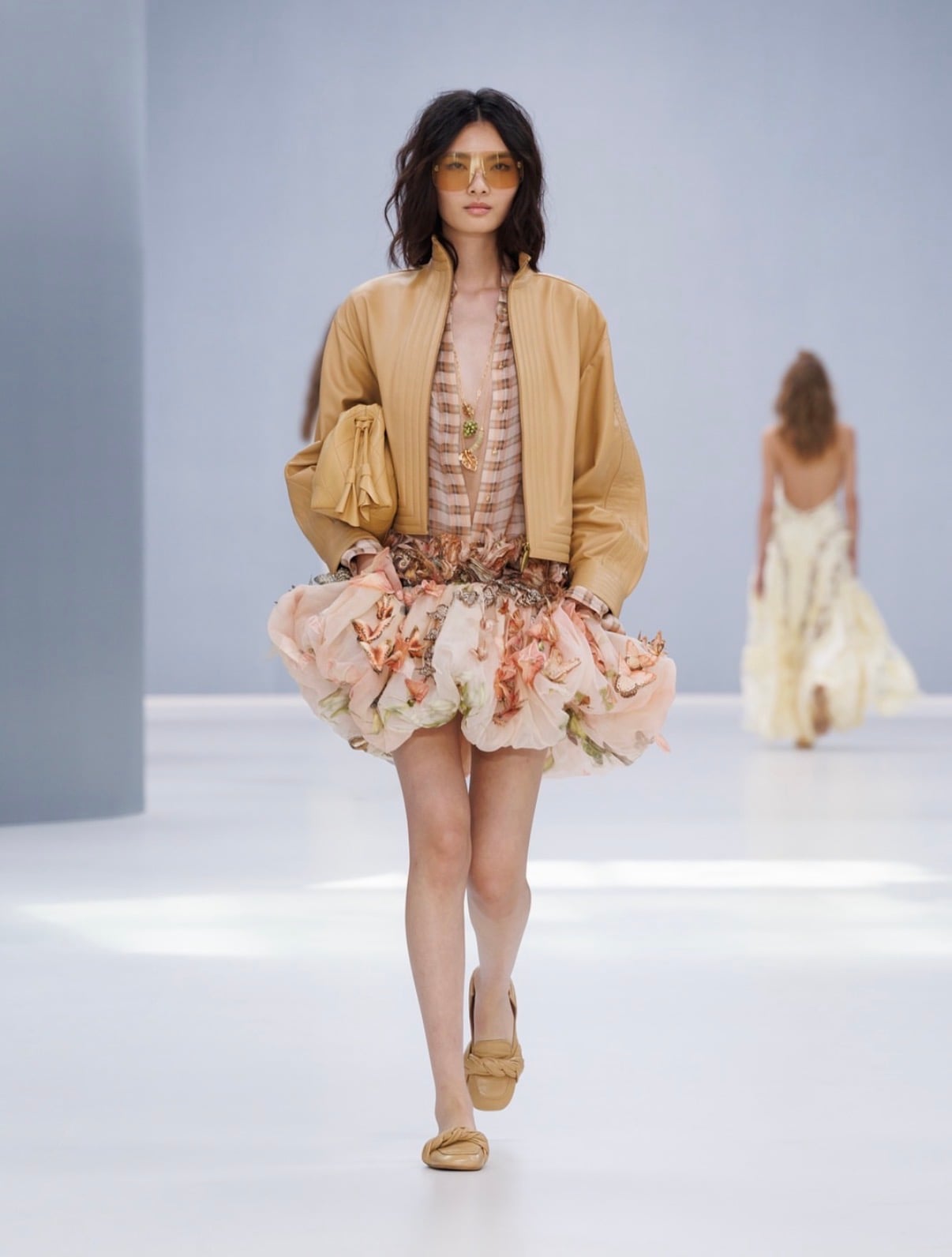 Modelo con Falda voluminosa con flores y camisa de cuadros con chamarra de piel color miel
