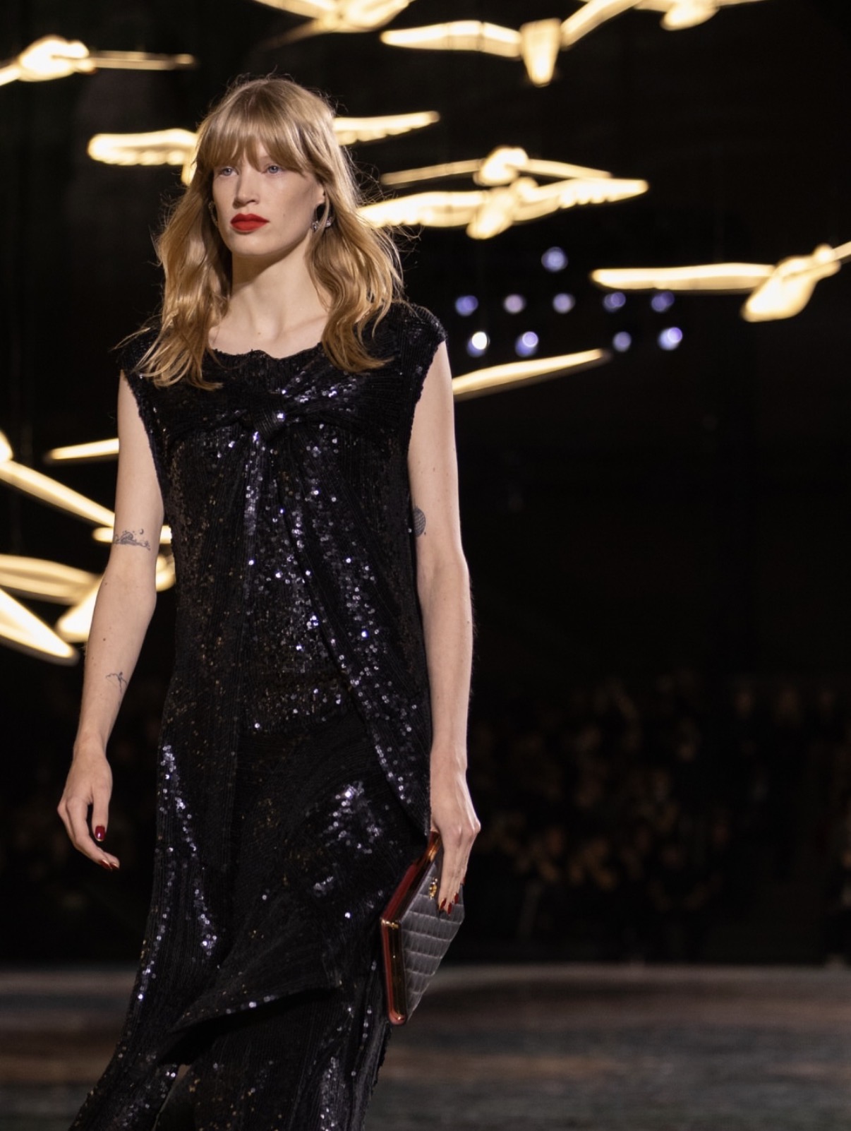 Modelo con vestido negro de brillos y labios rojos tendencias de belleza