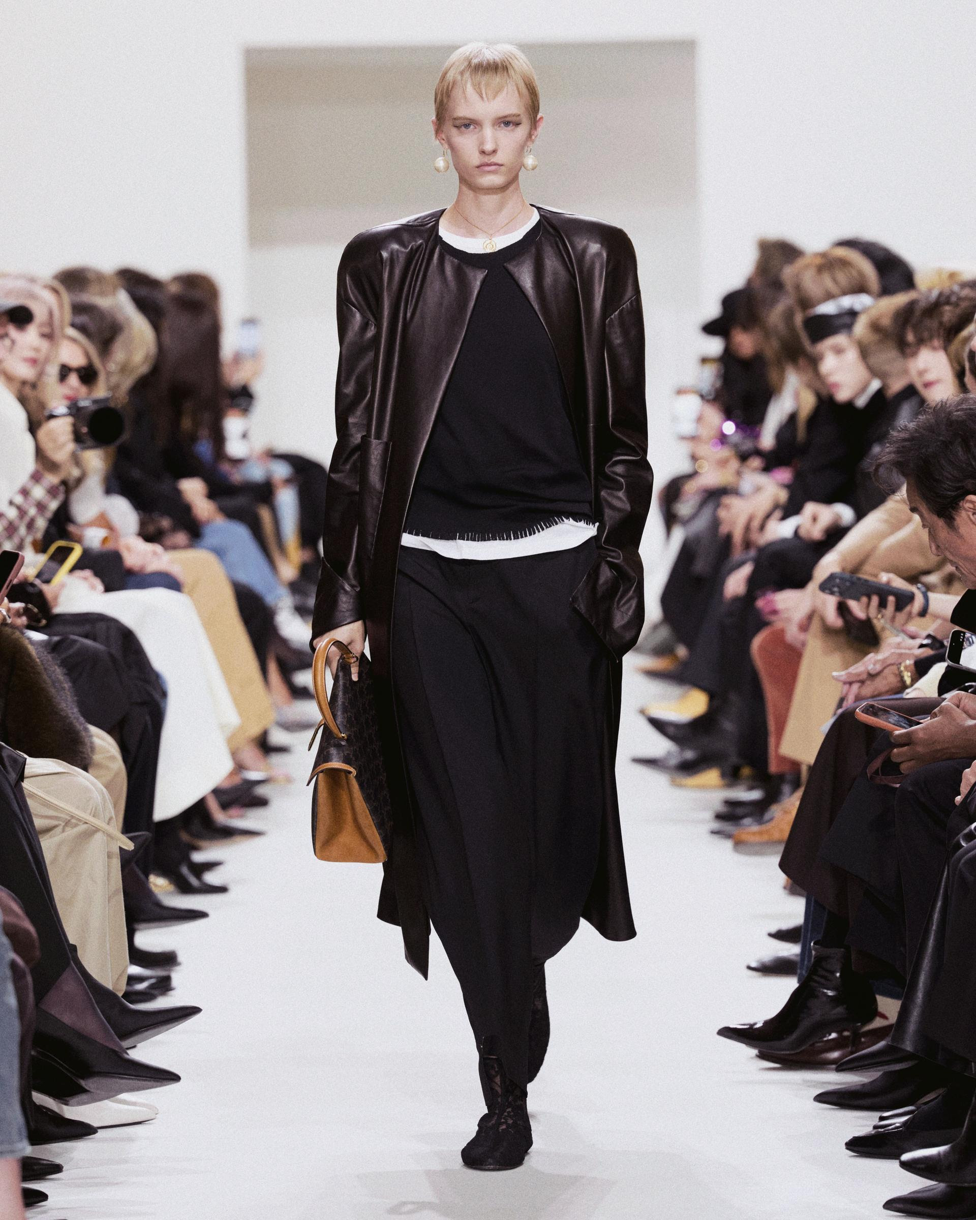Modelo con pantalones negros y gabardina de piel CELINE