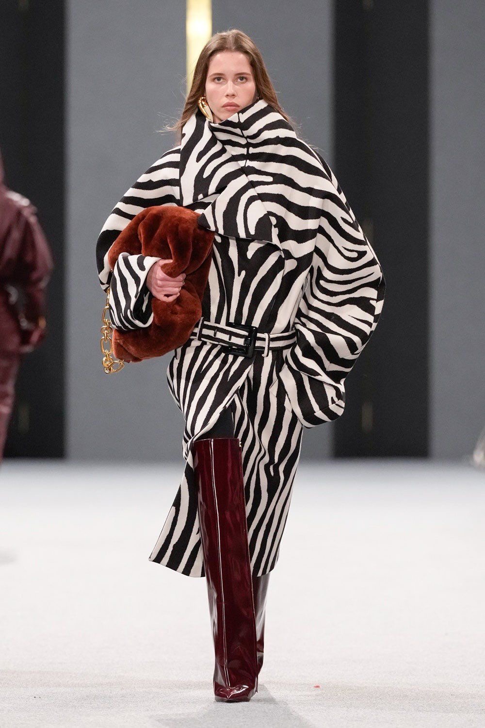 Modelo con Abrigo de zebra y botas largas vino