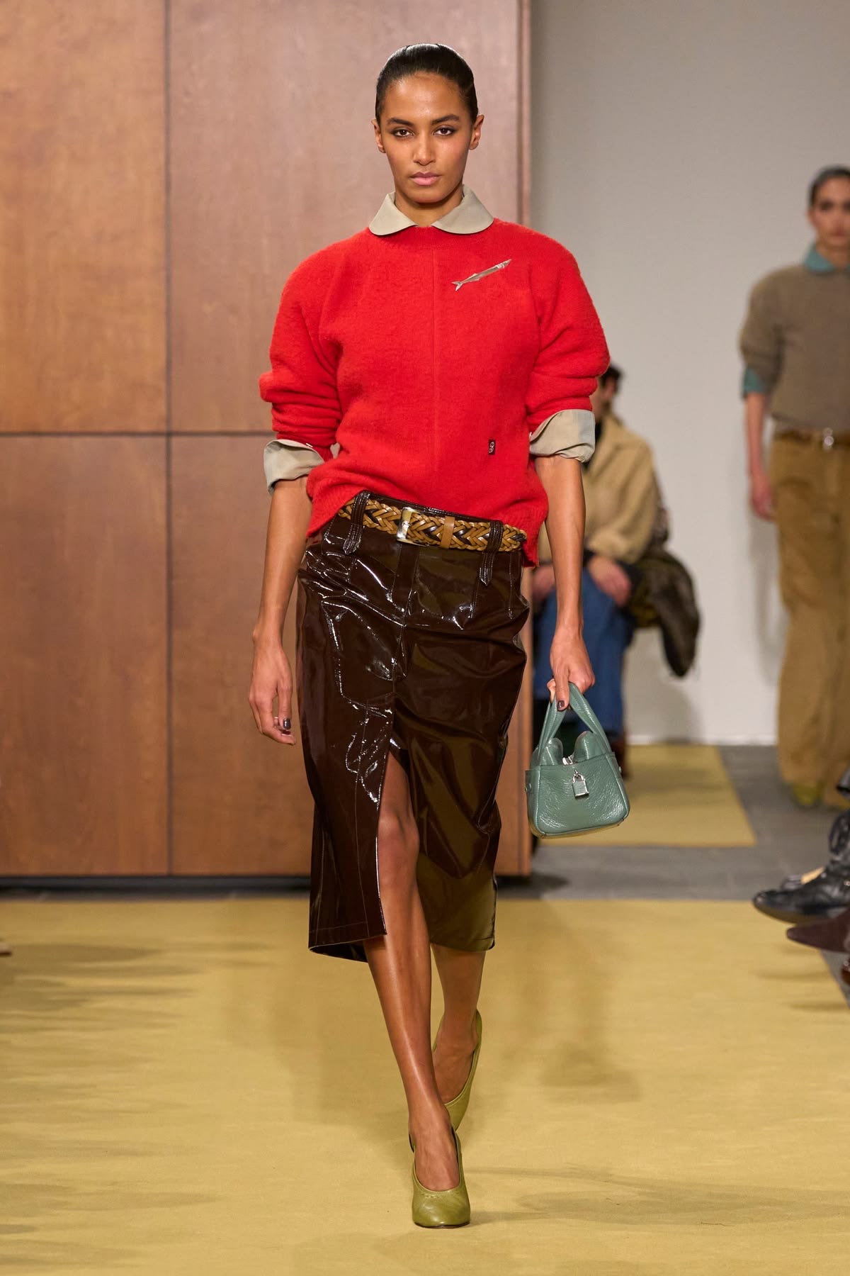 Modelo con falda lápiz café y suéter rojo