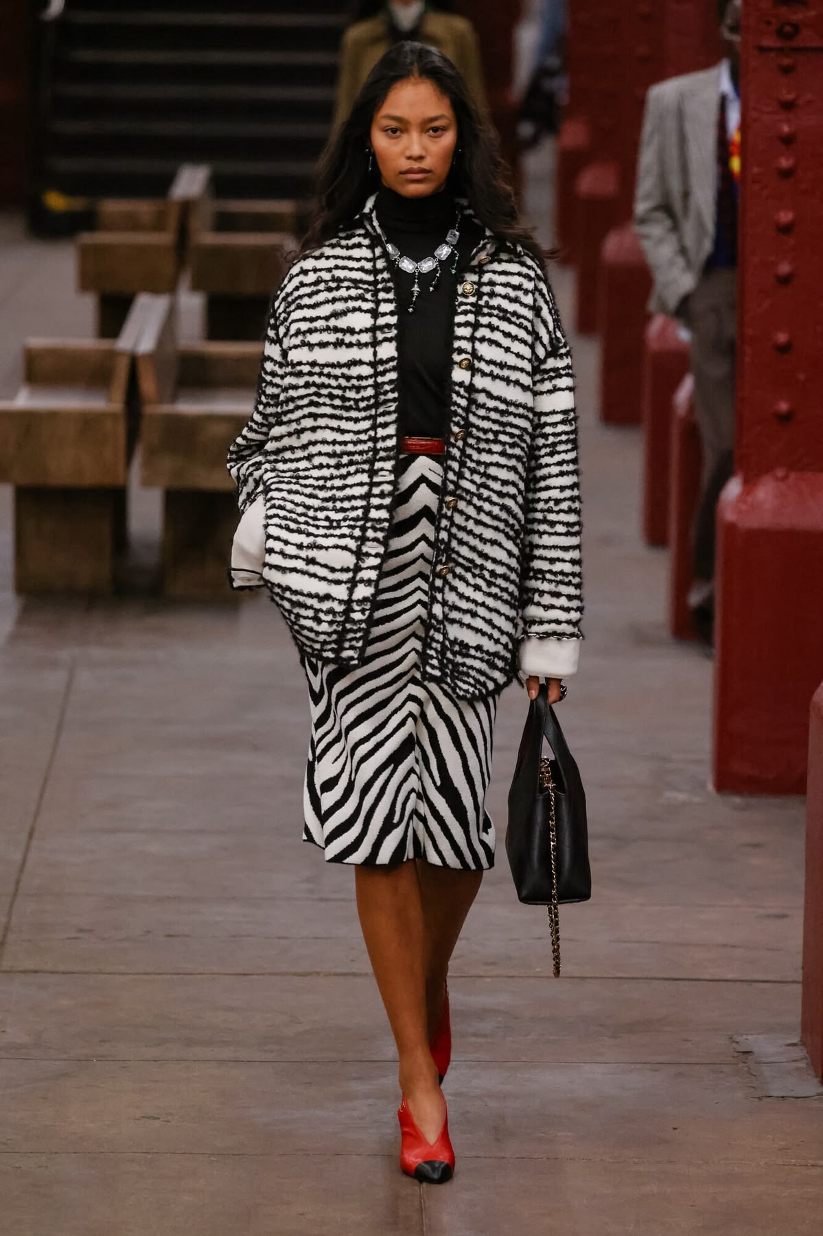 Modelo con abrigo y falda lápiz de zebra con tacones rojos