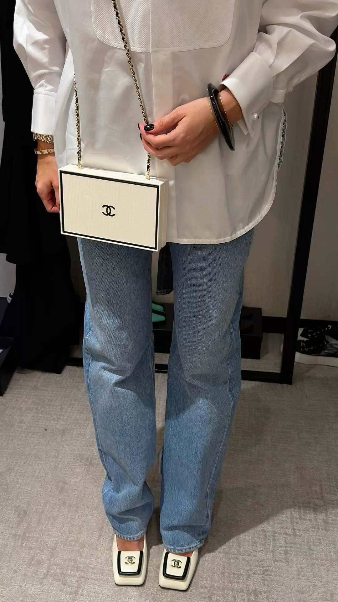 Camisa blanca con bolos Chanel y tacones negros con blanco