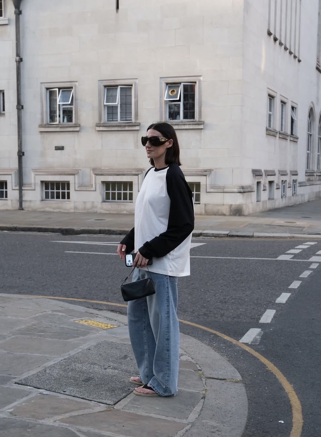 mujer de lentes con jeans y camiseta blanca con mangas negras