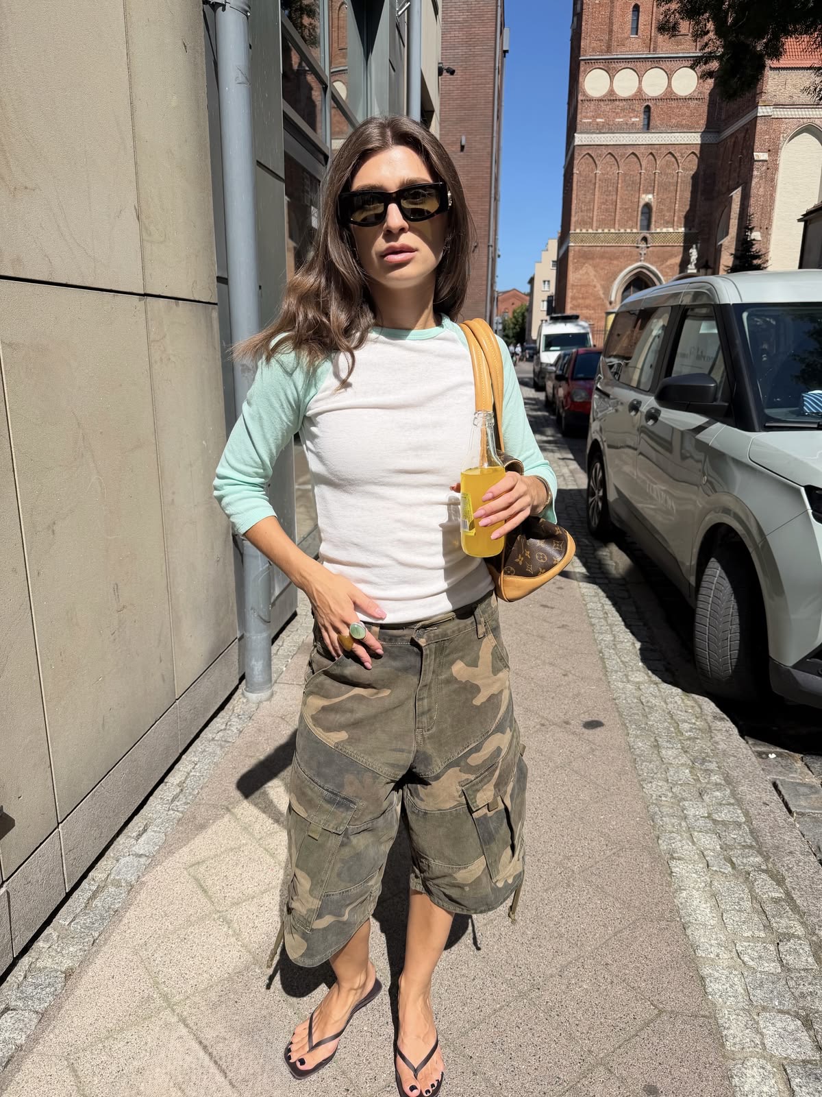 Mujer en la calle con pantalones capri camuflaje y camiseta de manga larga