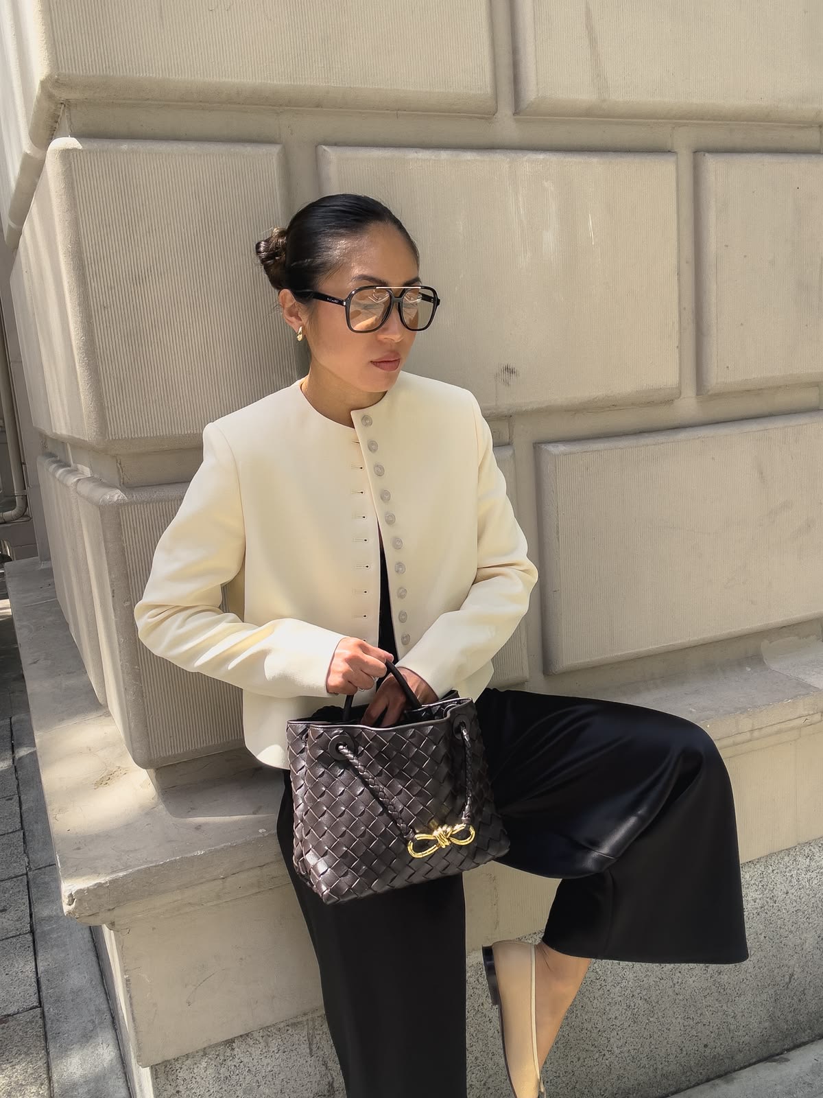 Mujer sentada con saco blanco sin cuello