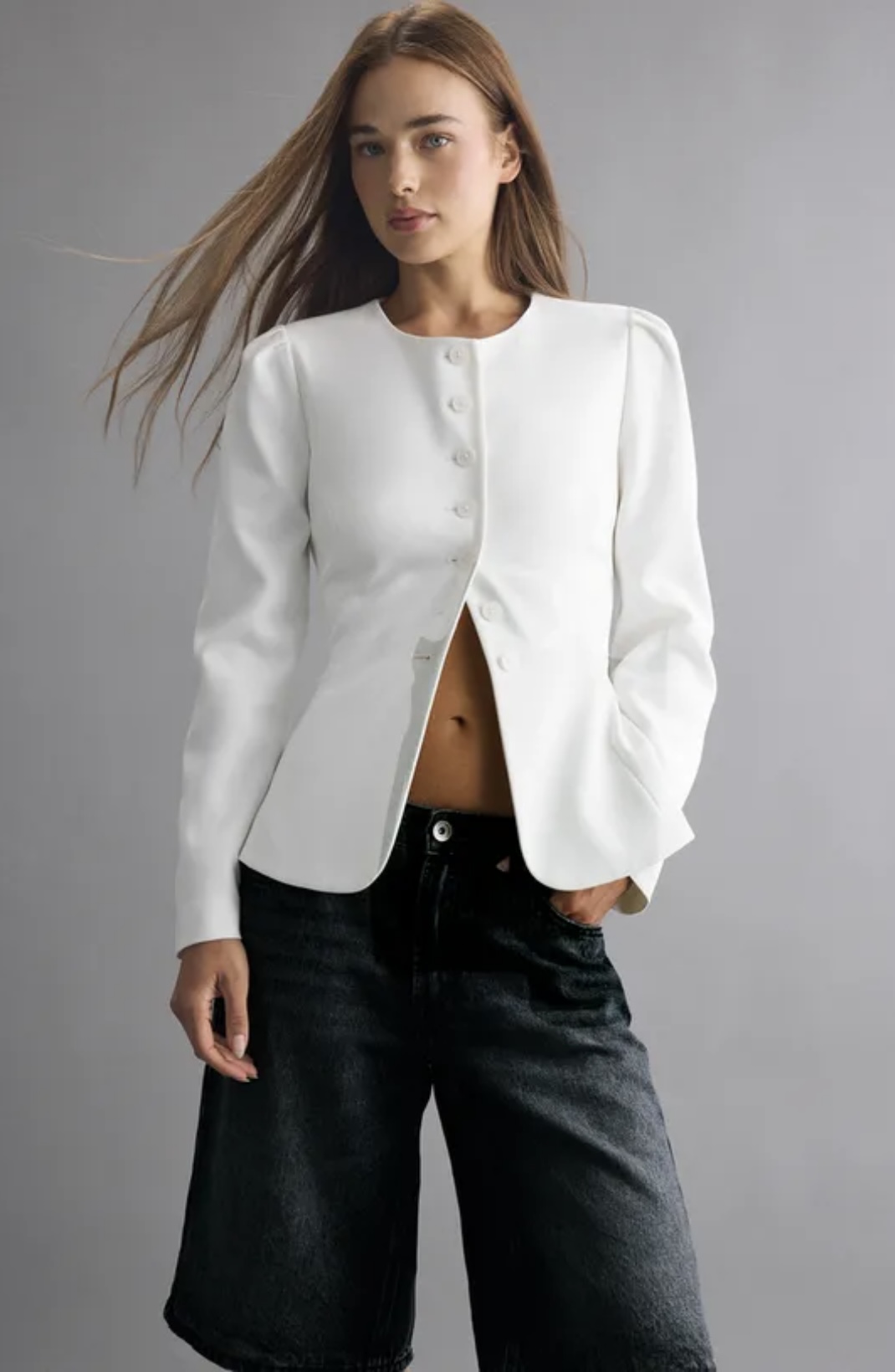Fondo gris con mujer en saco sin cuello blanco