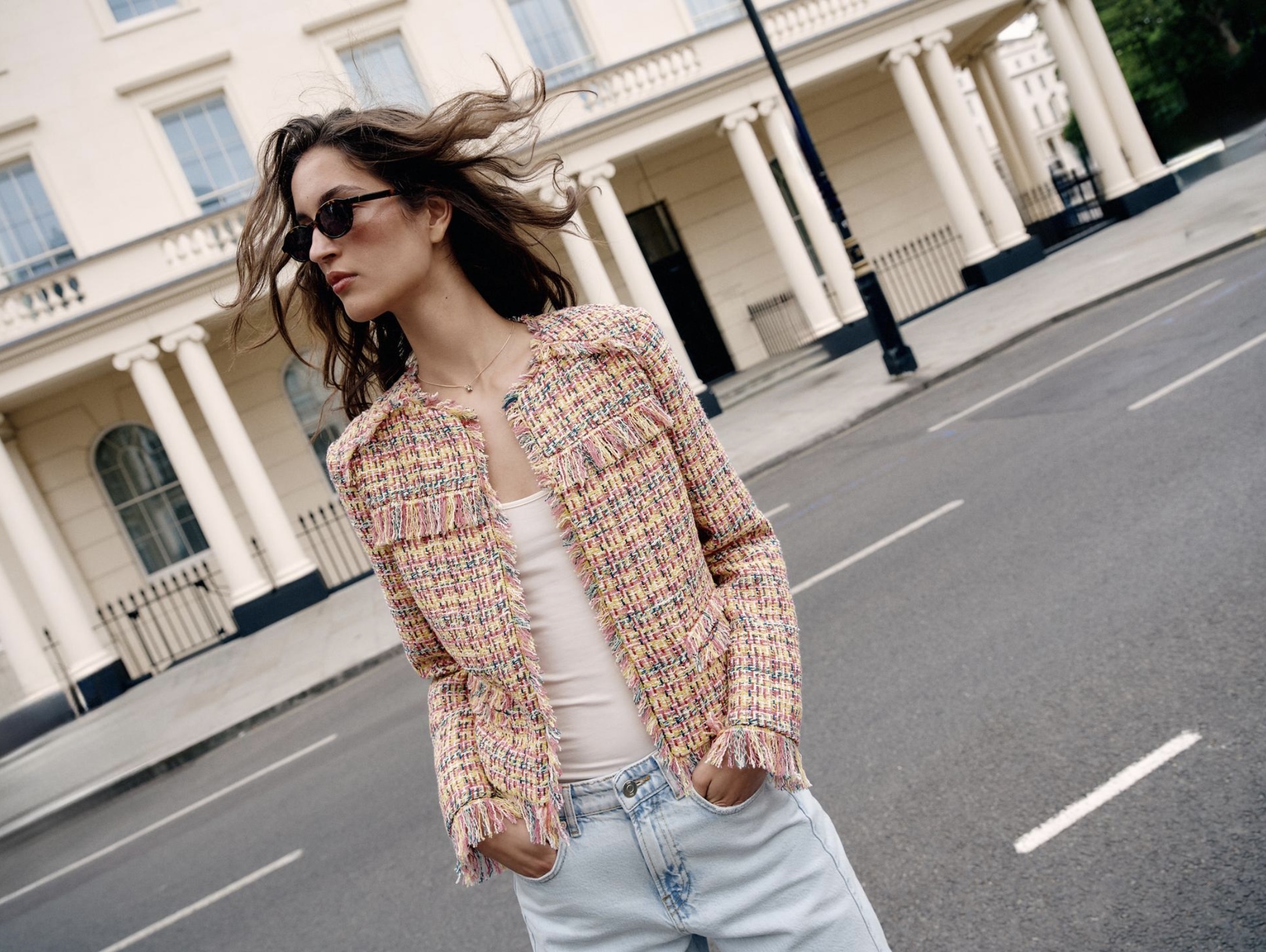Ciudad de fondo con mujer posando en saco sin mangas tweed