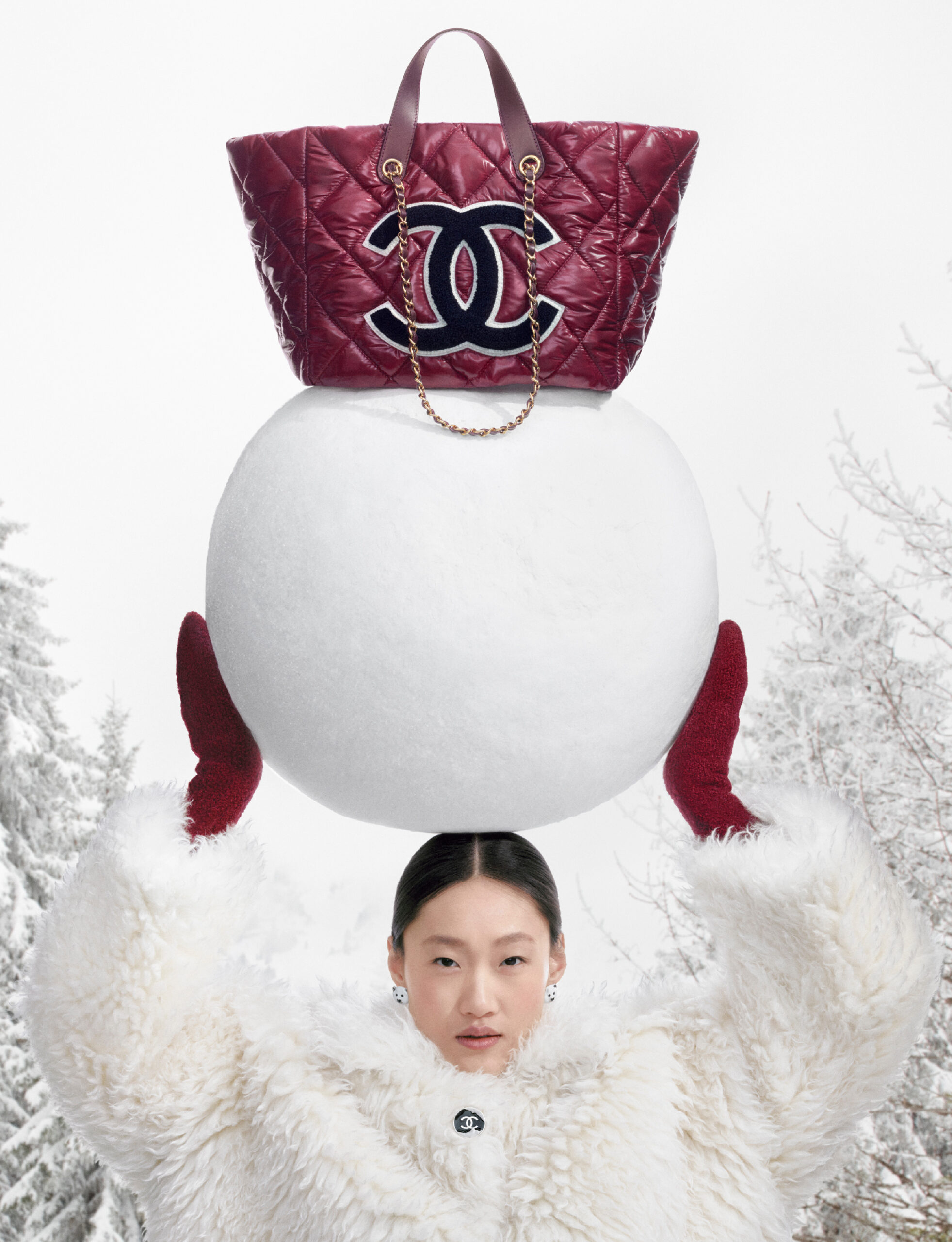 Modelo sosteniendo un Bolso burgundy CHANEL sobre una bola de nieve