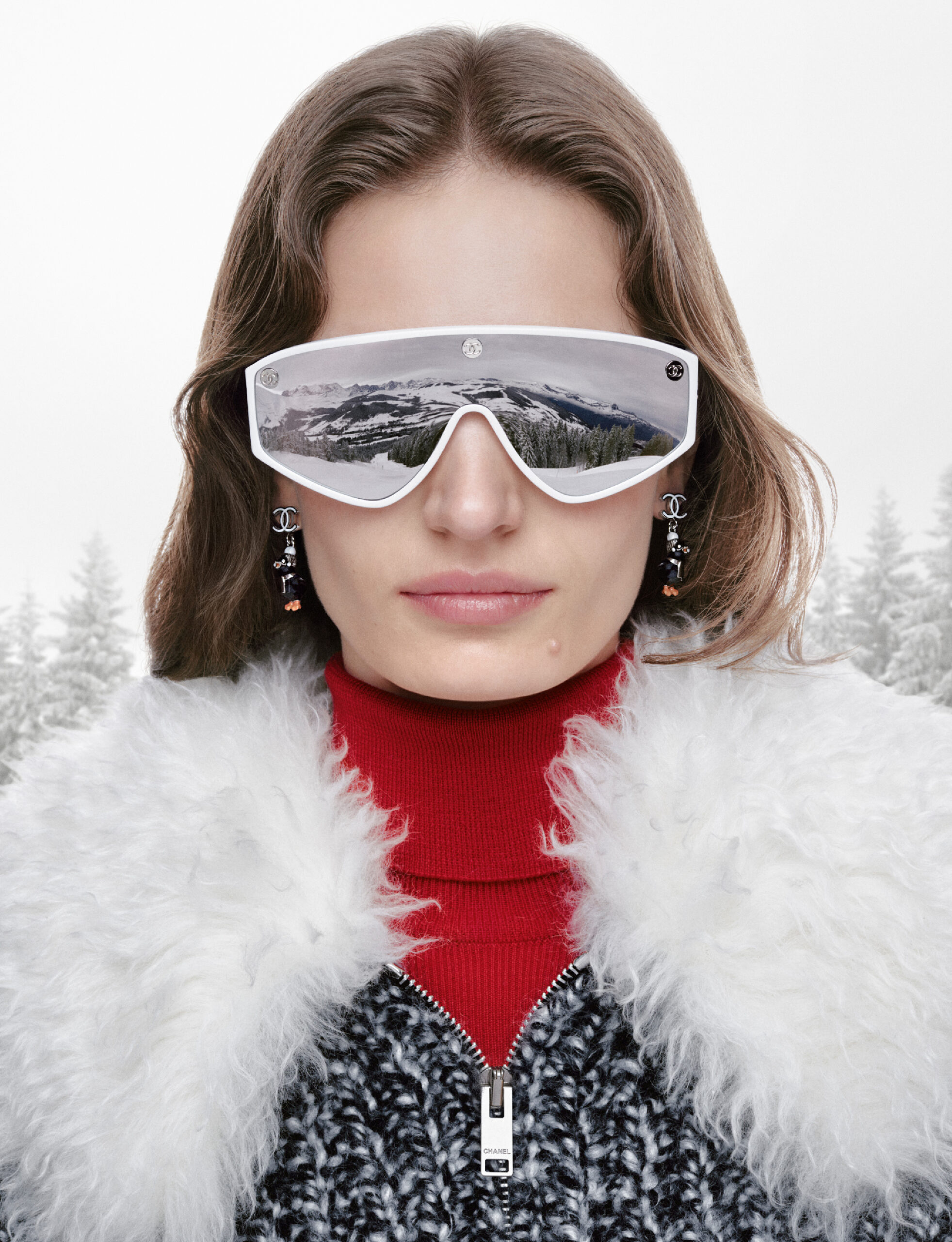modelo con lentes de ski con suéter rojo y chamarra de punto gris con blanco y fur