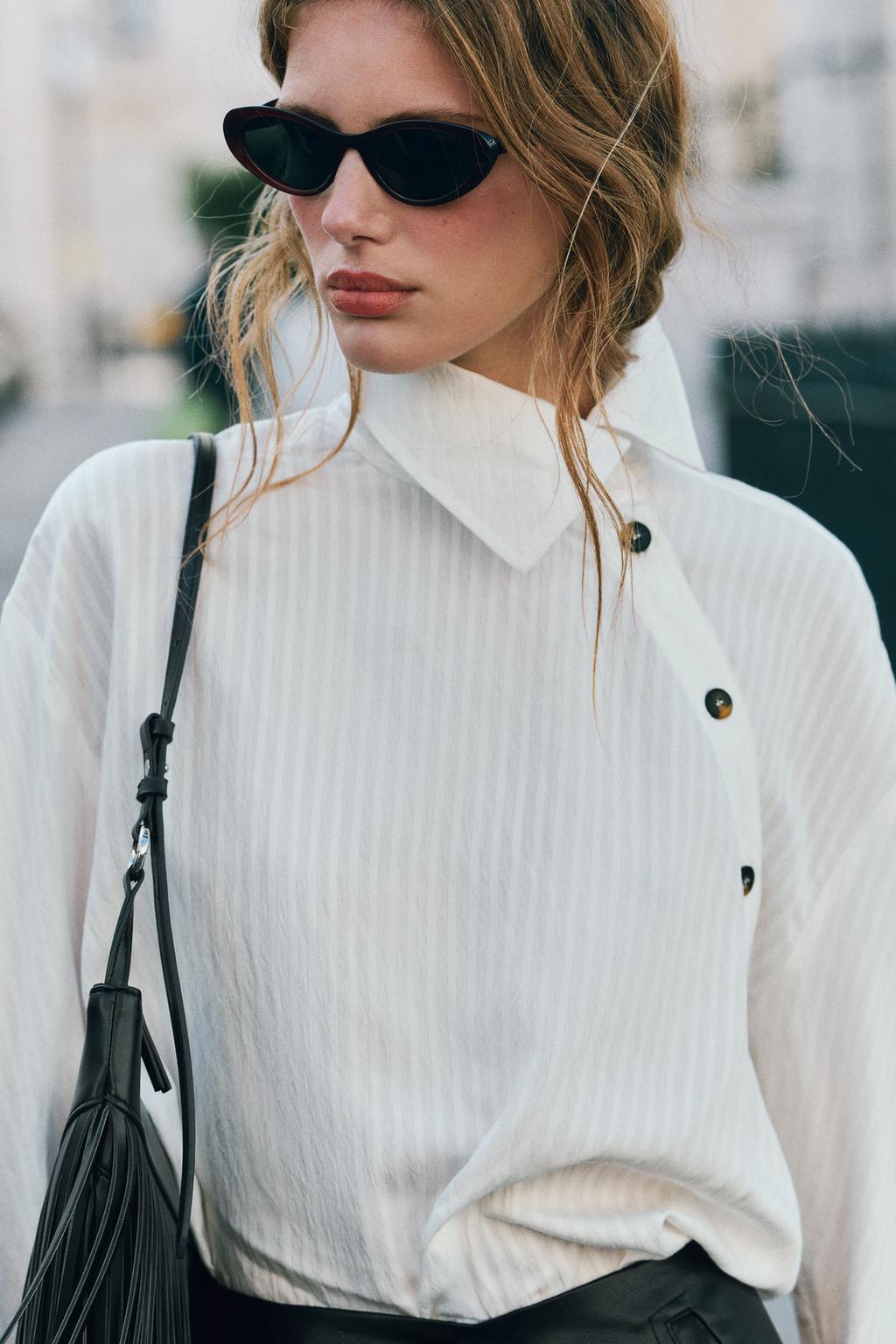 Mujer rubia con lentes obscuros y camisa blanca 