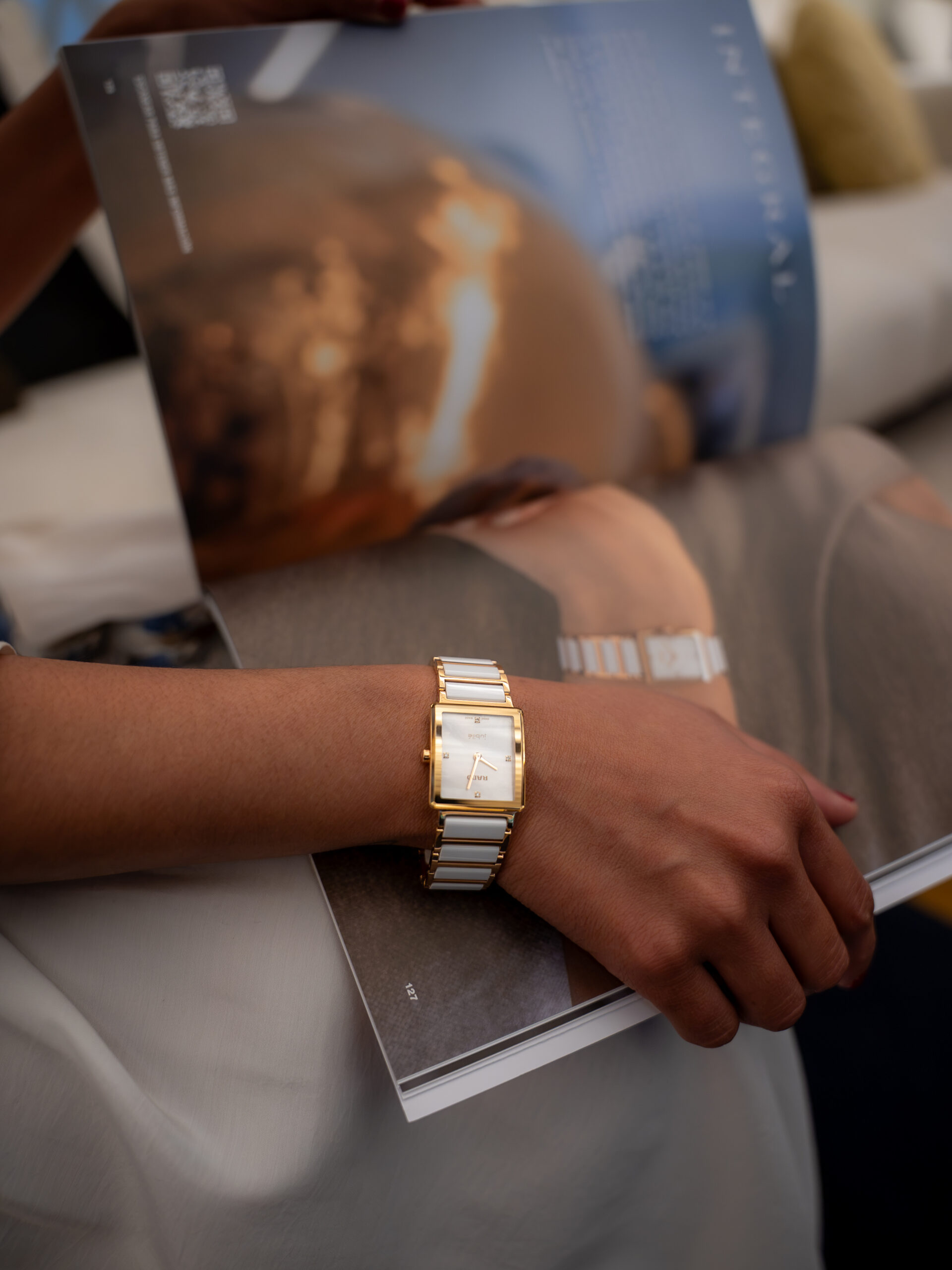 Reloj en muñeca con una revista de fondo 