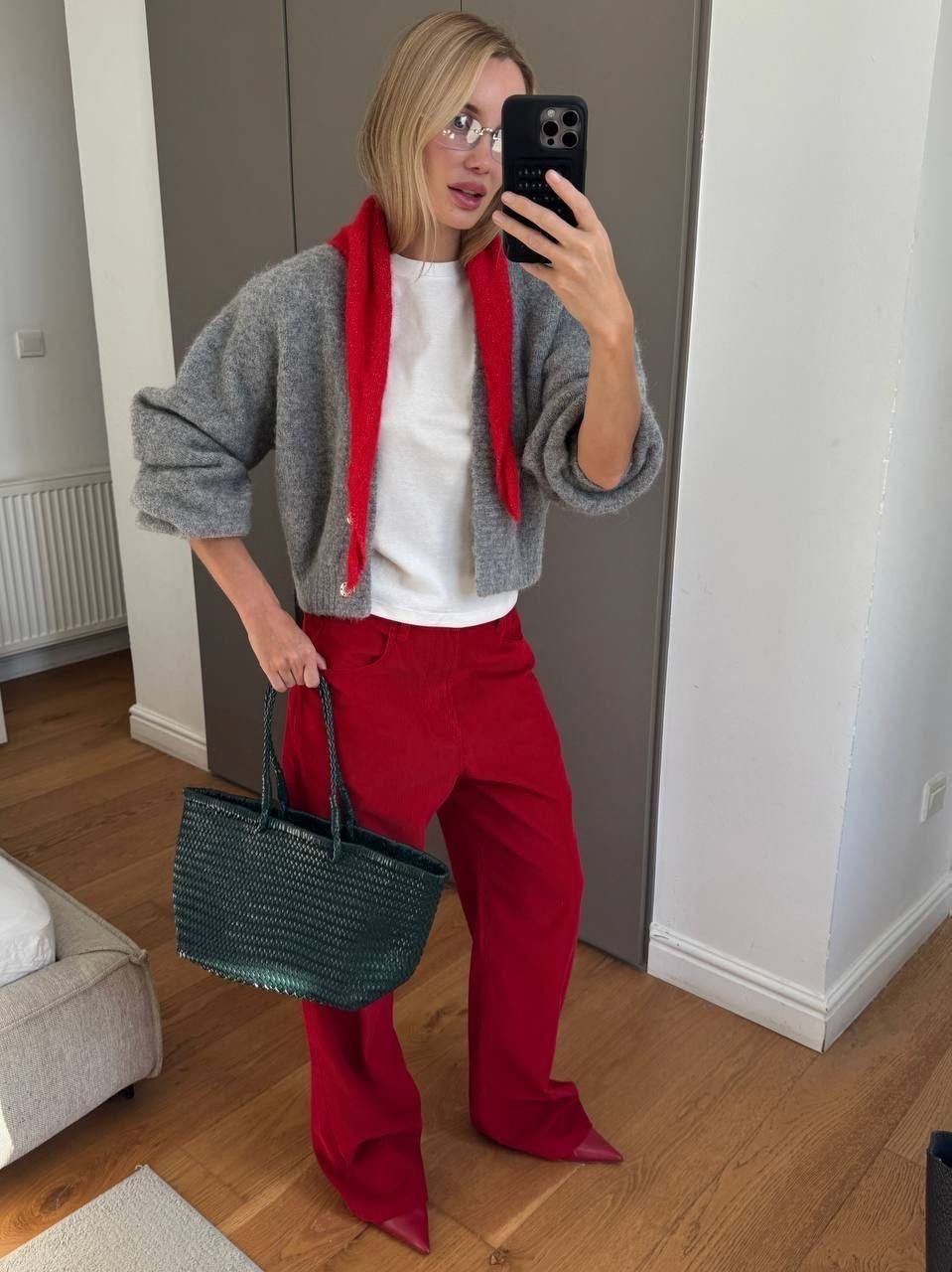 Foto de espejo con mujer de pantalones rojos y cardigan gris