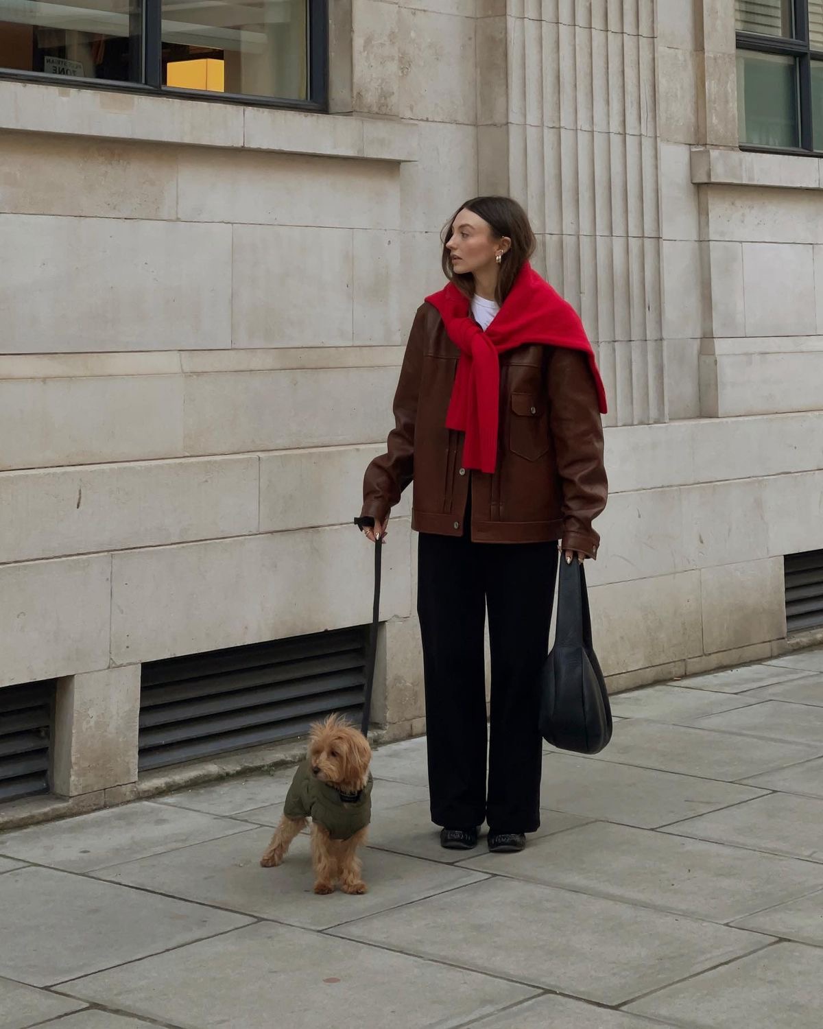 Calle de fondo con mujer con cardigan rojo amarrado a la espalda