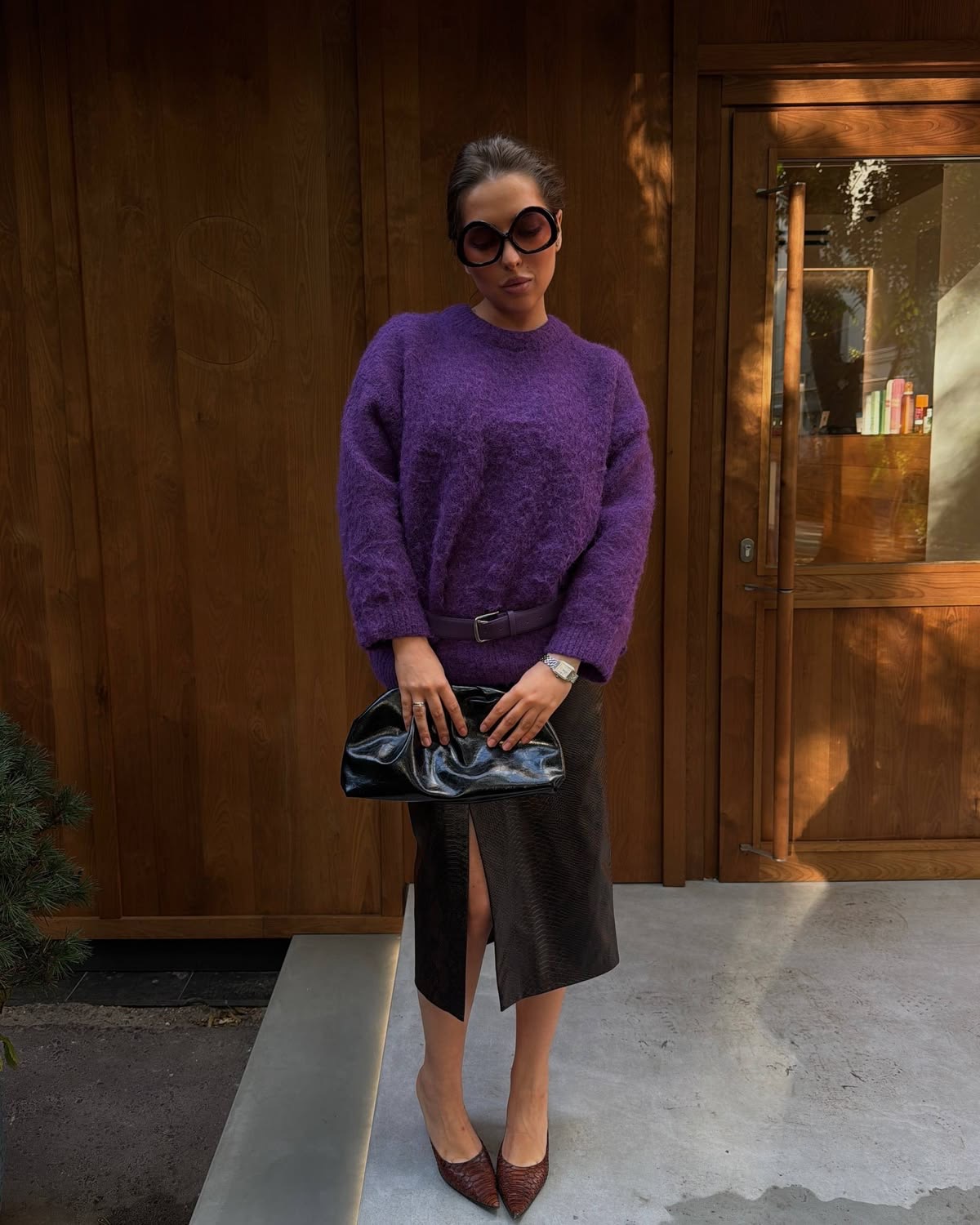 Modelo con lentes obscuros con filas lápiz negra y cardigan morado