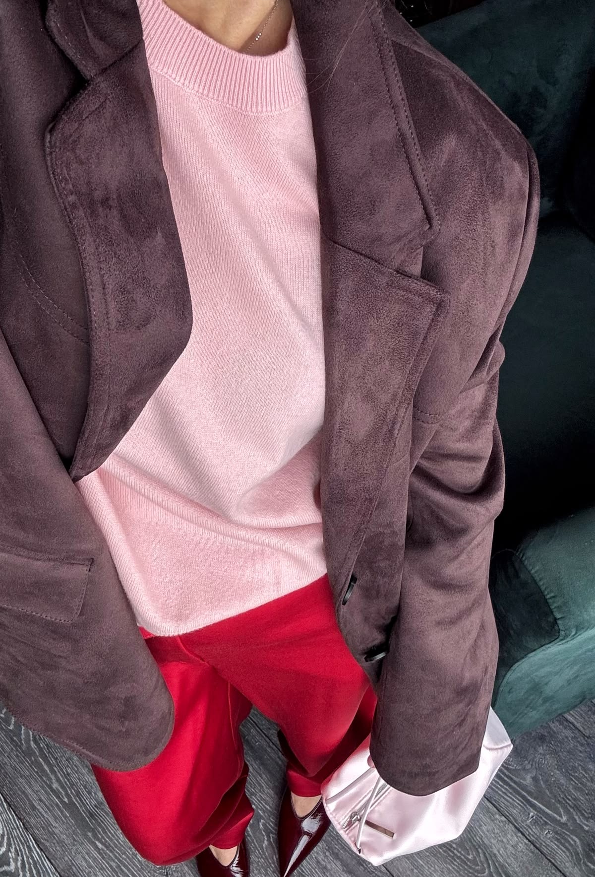 Pantalones rojos, cardigan rosa, y abrigo café