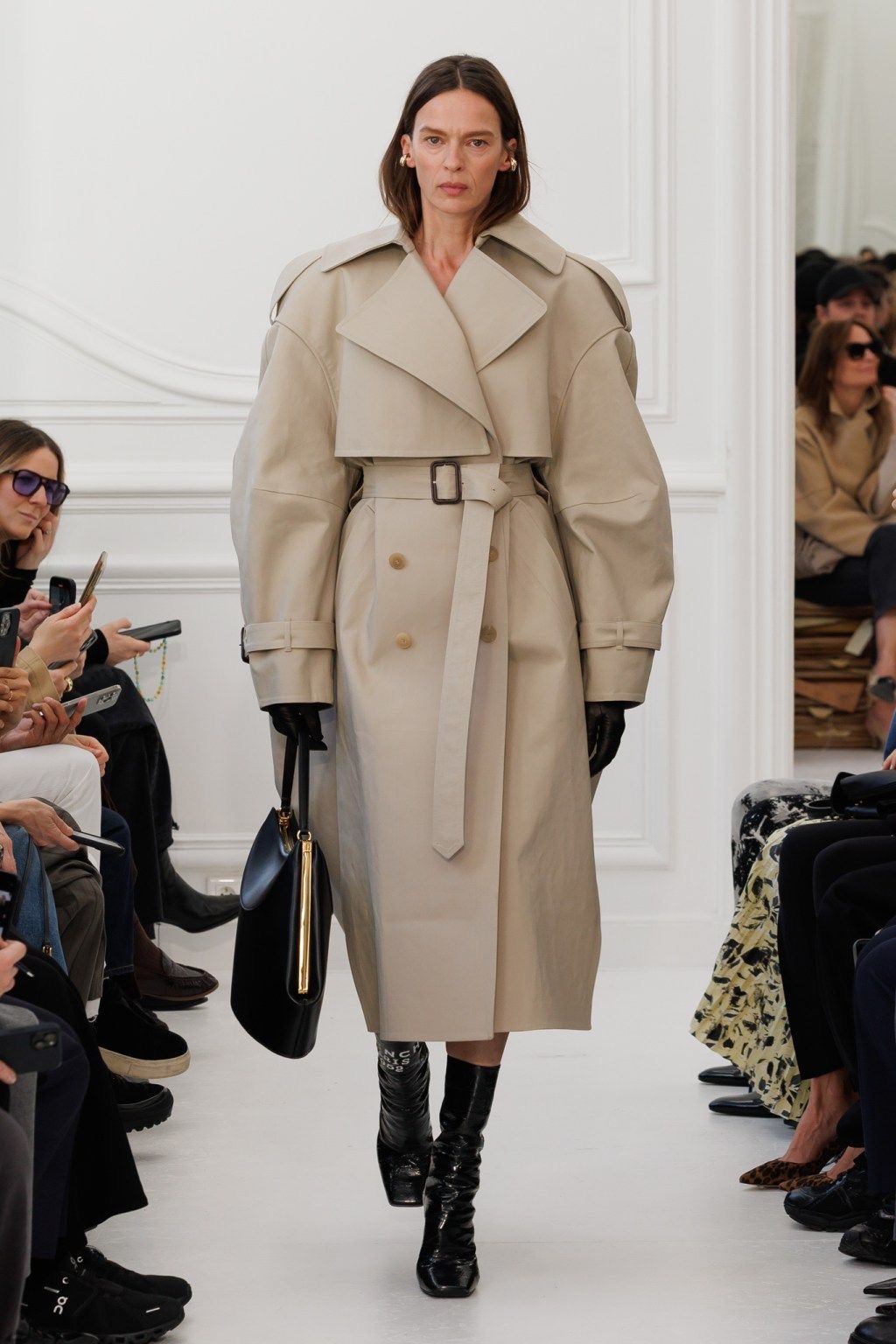 Modelo desfilando con trench coat largo beige 