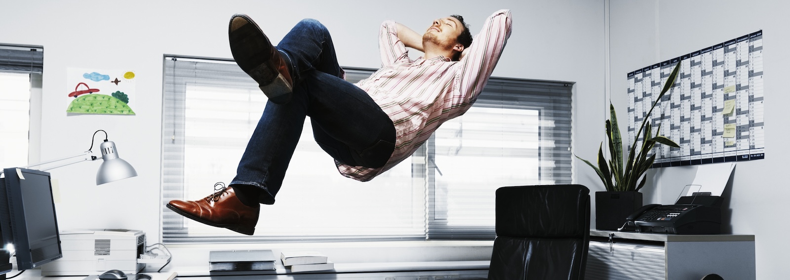 GETTY IMAGE - Man Floating in his office.