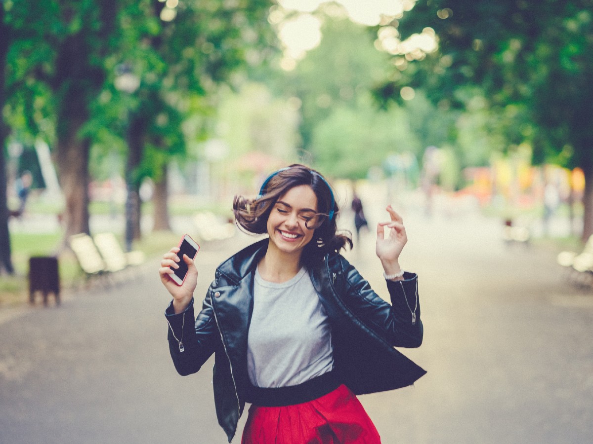 woman-happy-listening-to-music-dancing-in-the-street