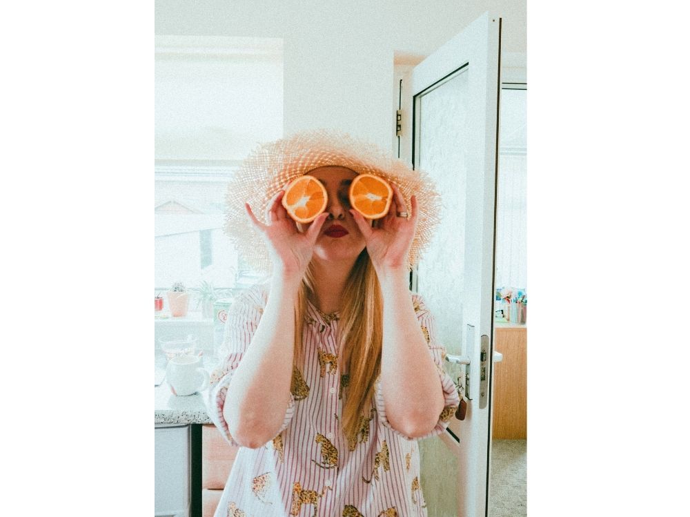 woman-holding-orange-in-half