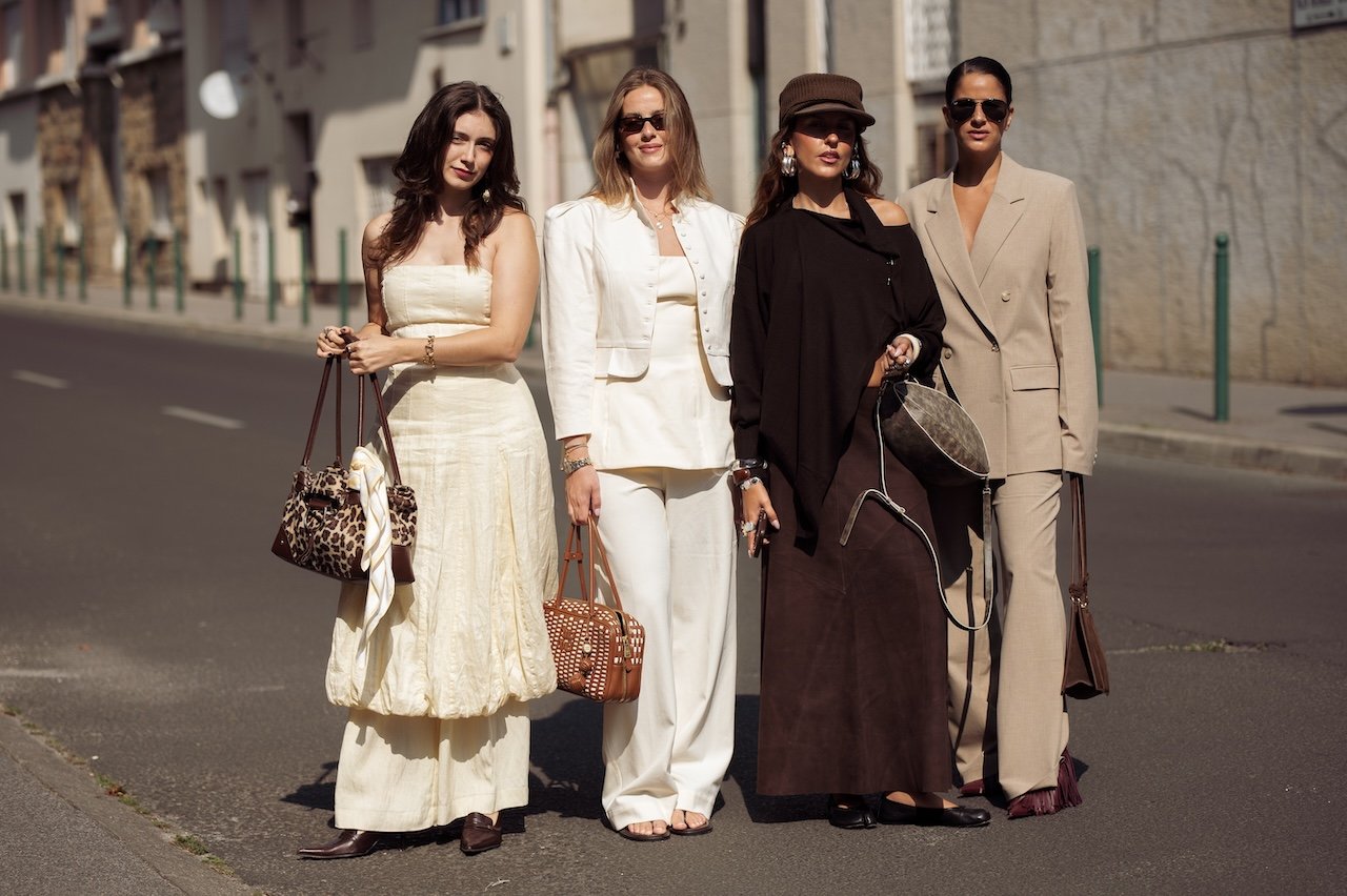 (L-R) Helena Mendes wears pale yellow strapless dress over the matching pants, animal print leopard bag with yellow scarf and Linoya Friedman wears white set made of pants and cropped jacket, beige top and brown Miu Miu bag and Sofia Coelho wears long brown maxi skirt, dark brown off shoulder asymmetrical top, brown hat and brown grey bag and Gili Biegun wears tailored Wide shoulder camel beige colour suit and Gia Borghini tassels fringe bordeaux burgundy plumps, brown suede framed bag
