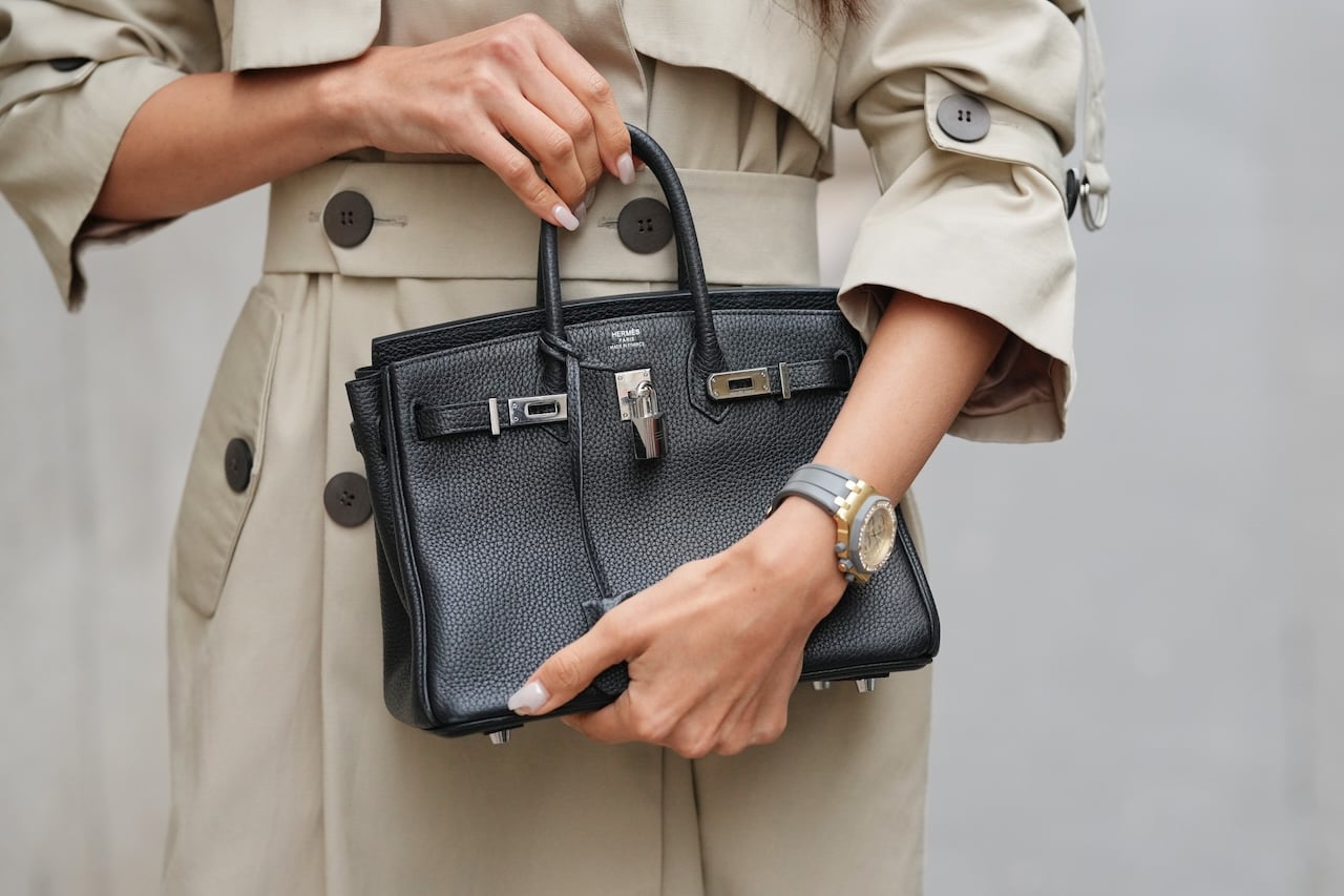 PARIS, FRANCE - DECEMBER 11: Patricia Gloria Contreras wears a trench coat, a watch by Audemars Piguet, and a structured black leather top-handle Birkin bag by Hermes, during a street style fashion photo session, on December 11, 2025 in Paris, France. (Photo by Edward Berthelot/Getty Images)
