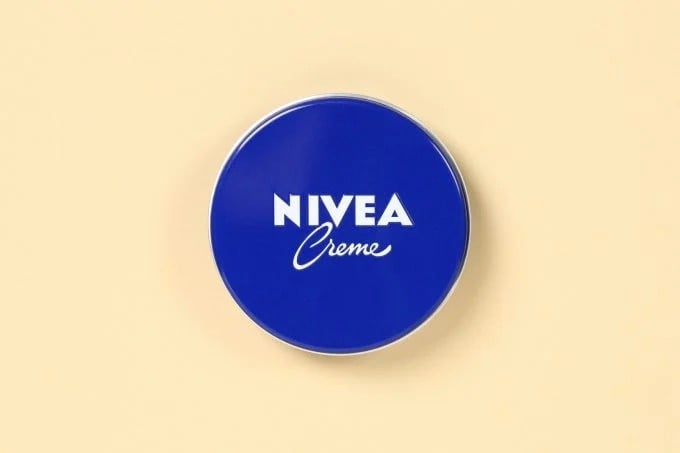 nivea blue cream tin on a yellow background