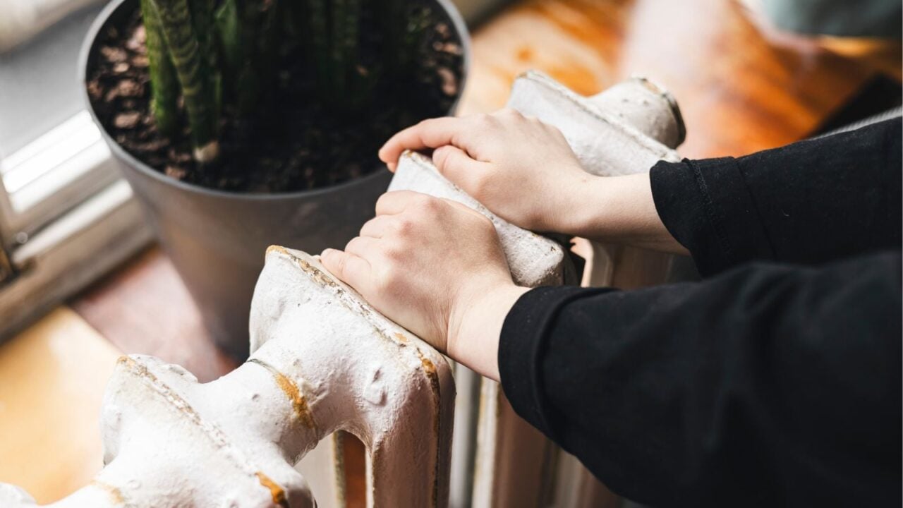 a pair of hands resting on a radiator